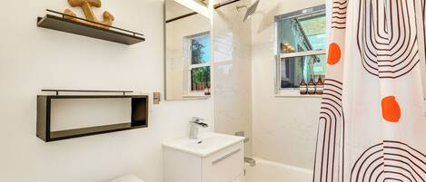 Ein modernes Badezimmer mit Toilette, Waschbecken, Waschtisch und Badewanne.