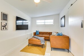 A modern living room with a brown leather sofa, a matching armchair, and a wooden floor. - 3 Mi to Sea! Family Pool House in Fort Lauderdale (Fort Lauderdale)