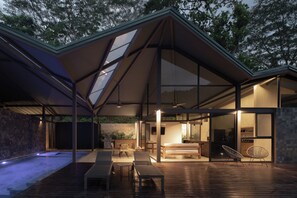 A modern house with a spacious deck, a dining area, and a kitchen. - Elevated Escape - Our jungle house, Minutes away from Playa Mantas, 3BR (Quebrada Ganado)