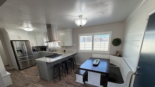 A modern kitchen with a central island, stainless steel appliances, and a window providing natural light.