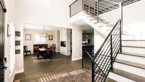 Un intérieur moderne comprenant un escalier, un coin repas et une cuisine.