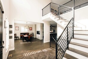 Ein modernes Interieur mit Treppe, Essbereich und Küche.