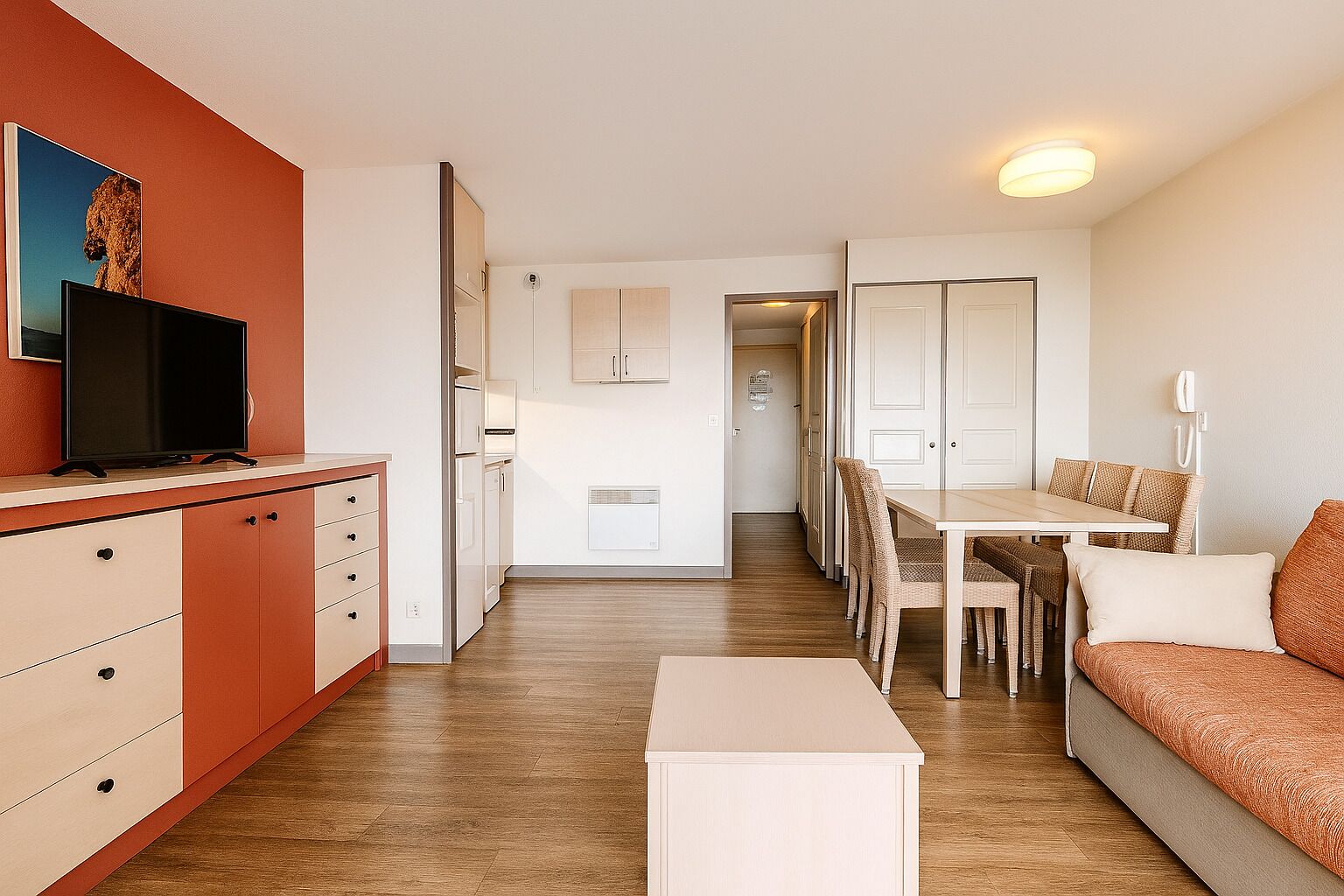 Eine moderne Wohnung mit Wohnbereich, Essplatz und Küchenzeile.