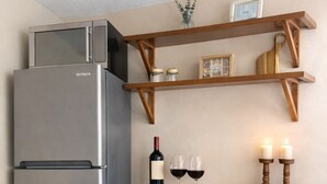 Eine Küche mit einem Edelstahl-Kühlschrank, Holzschränken, einer Arbeitsplatte und einem Regal mit Dekoration.