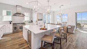 A modern kitchen with a large island, stainless steel appliances, and pendant lighting. - NEW! Lux Beachfront, Views, Heated Pool, Sleeps 24 (Panama City Beach)