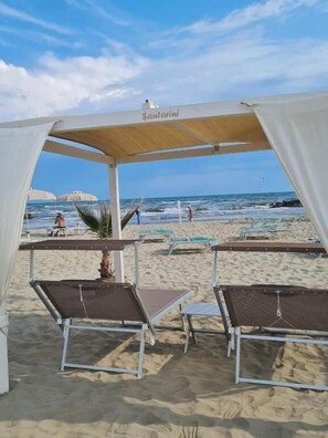 Privat strand, vit sandstrand, parasoller och strandhanddukar