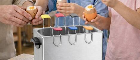 Une cuisine équipée d’appareils électroménagers en acier inoxydable, d’une plaque à gaufres et d’un appareil à gaufres posés sur le plan de travail.