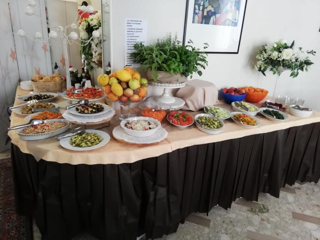 A buffet table with various food items and a potted plant.