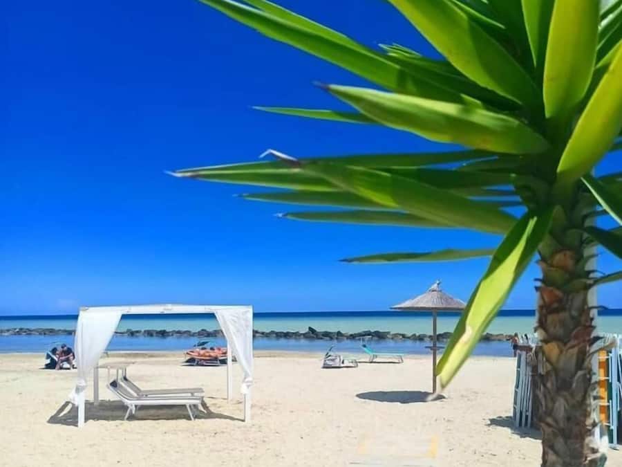 Plage privée, sable blanc, parasols, serviettes de plage