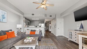 Ein modernes Wohnzimmer mit einer Couch, einem Couchtisch und einem Deckenventilator.