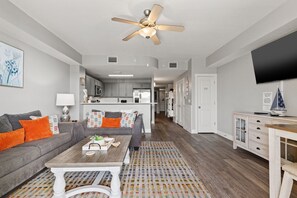 A modern living room with a sofa, coffee table, and a ceiling fan. - Calypso 3 by Pier Park! Third floor-No Elevators! 1 BR/ Bunks/ 2 Baths. (Panama City Beach)