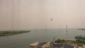 A view of a river with industrial structures and a bridge in the distance. - LUXURY 4BED APARTMENT IKOYI (Lagos)