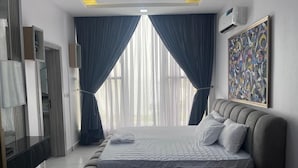 A modern bedroom with a large bed, a TV, and a painting on the wall. - LUXURY 4BED APARTMENT IKOYI (Lagos)
