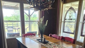 A dining area with a wooden table, red chairs, a bench, and a vase with plants. - Mountain views, quiet location, Close to Fort Sill and Medicine Park! (Lawton)