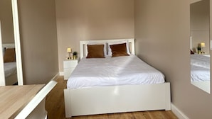 A bedroom with a white bed, a nightstand with a lamp, and a mirror on the wall. - Bohemian Stay Central Lisbon Rooms (Lisbon)
