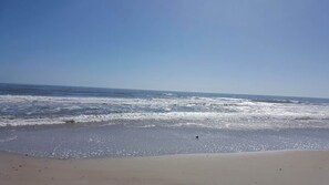 A beach with waves, a clear sky, and a sandy shore. - Evy's Wave - Sound View - Dogs Allowed (North Topsail Beach)