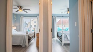 A bedroom with a bed, a nightstand, and a ceiling fan. - Great Catch - Double Duplex - Dogs Allowed - Wraparound Deck (North Topsail Beach)