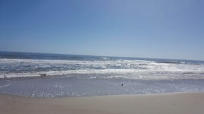 A beach with waves, a clear sky, and a sandy shore. - So Free - Dogs Allowed - Walk to Beach (North Topsail Beach)