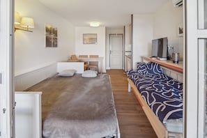 Ein Zimmer mit einem Bett, einem Schreibtisch und einem Fernseher.