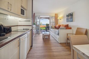 Un espace de vie compact comprenant une cuisine, un coin repas et un ensemble de canapés.