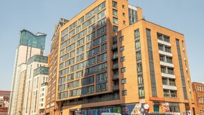 Un hotel de varios pisos con un diseño moderno, con amplias ventanas y una entrada destacada.
