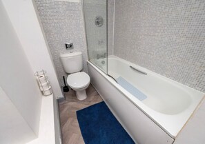 A modern bathroom with a toilet, a glass-enclosed shower, and a bathtub. - Luxury City Flat ✦ Steps to O2 Academy & Dining (Birmingham)