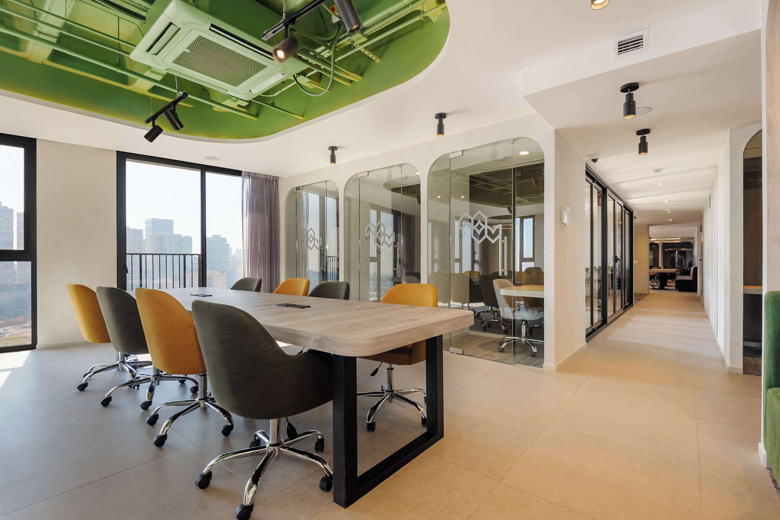 Une salle de conférence moderne, dotée d’une longue table et de chaises, de grandes fenêtres et offrant une vue sur la ville.