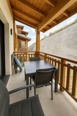 A covered outdoor area with a table and chairs, a wooden deck, and a view of a hillside. - T3 in the heart of Valberg, close to the slopes, heart of the resort, heated swimming pool (Péone)