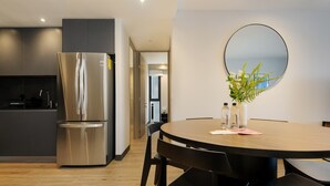 Una cocina moderna con un refrigerador de acero inoxidable y un comedor con una mesa redonda y sillas.