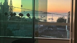 A view through a window with a clear sky and a distant landscape.