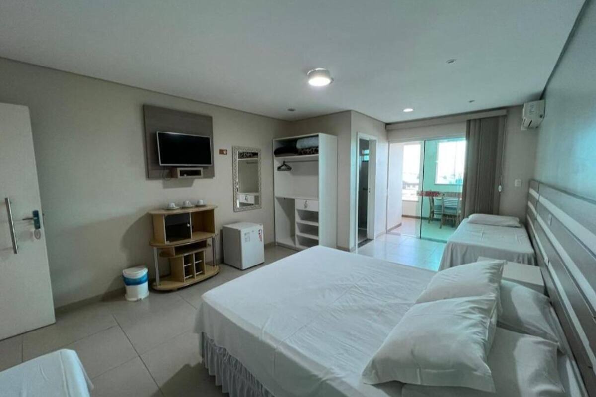 Une chambre d’hôtel avec un grand lit, une télévision, une armoire et un bureau.