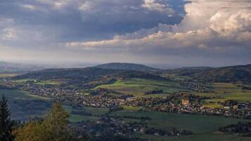A panoramic view of a town nestled in a valley with rolling hills in the background.
