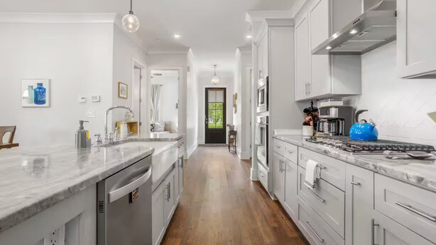 A modern kitchen with a central island, stainless steel appliances, and a view to the outside. - Serene Beach Oasis with Heated Pool (Biloxi)