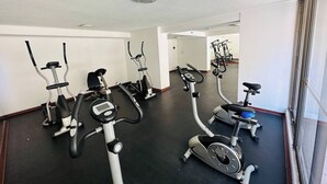 Ein Fitnessraum mit mehreren Fahrrädern und Crosstrainern.