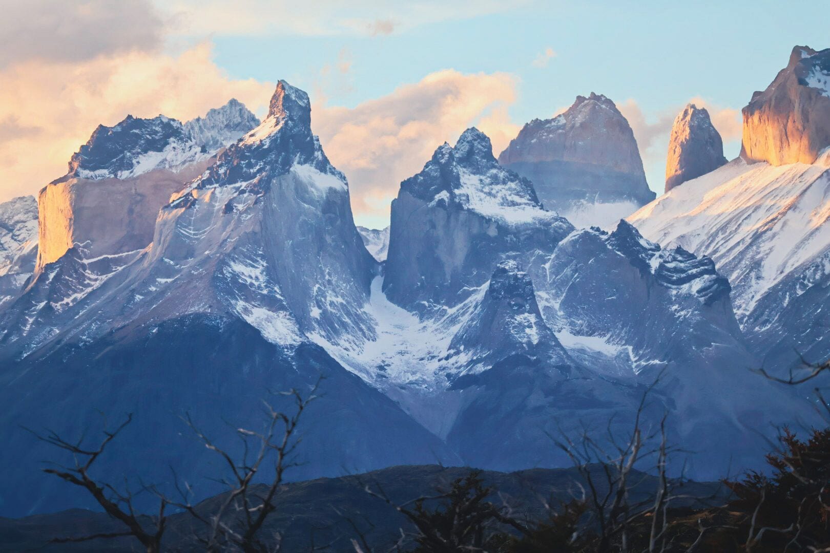 A mountainous landscape with snow-covered peaks and a clear sky.