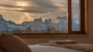 Un dormitorio con un ventanal grande que da a un paisaje montañoso.
