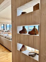 A modern interior with wooden paneling, a sofa, and woven baskets on shelves.