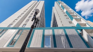 Un edificio alto de diseño moderno, con una farola destacada en primer plano.