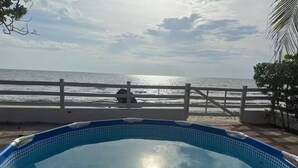 Ein Schwimmbecken mit Blick auf den Ozean und einem weißen Zaun.