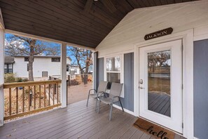 A covered porch with a wooden deck, two metal chairs, and a door labeled "JACKSON". - The Resort at Fredericksburg Unit 9 (Fredericksburg)