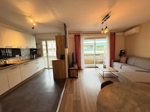 A modern apartment with a kitchen, dining area, and living room. - Modern apartment with terrace - ideal location (Cagnes-sur-Mer)