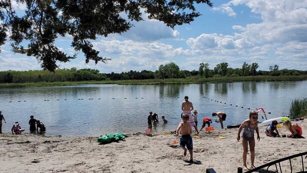 A lakeside scene with people engaging in various activities near the water.