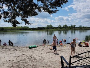 A lakeside scene with people engaging in various activities near the water.