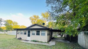 A single-story house with a small porch and a satellite dish.
