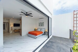 A modern bedroom with a bed, bedside tables, and a ceiling fan. - Unit Elote Romantic Zone (Puerto Vallarta)
