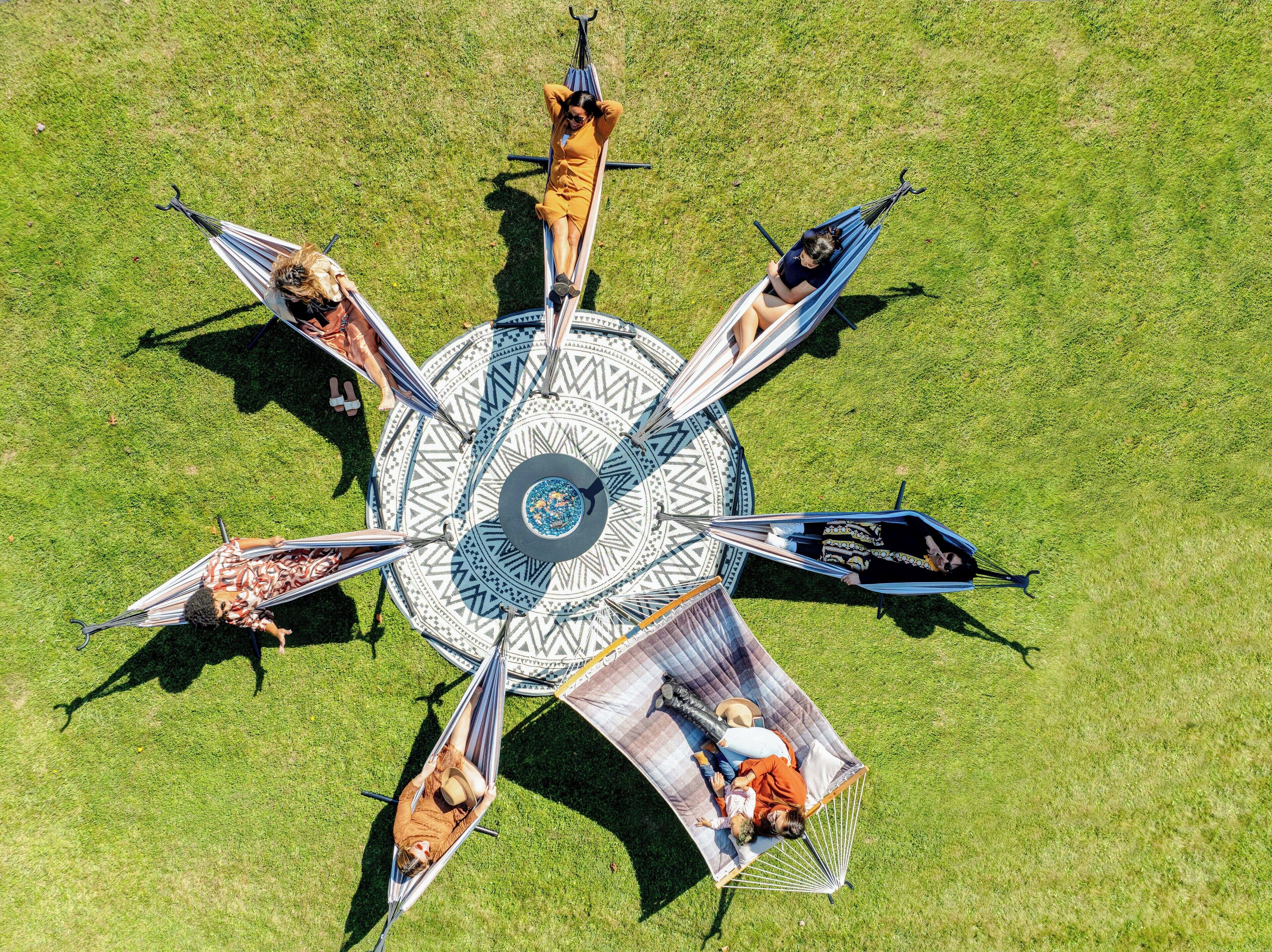 Un espace extérieur circulaire aménagé avec plusieurs hamacs et un élément décoratif central.