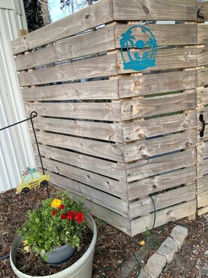 A wooden fence with a guest parking sign, a welcome sign, and a potted plant with red flowers. - Not available  (North Myrtle Beach)