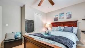 A bedroom with a wooden bed, a nightstand, a bench, and a door. - 3-bedroom house in awesome Ellenwood with cool AC breeze (Ellenwood)