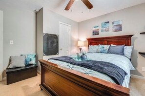 Ein Schlafzimmer mit einem Holzbett, einem Nachttisch, einer Bank und einer Tür.