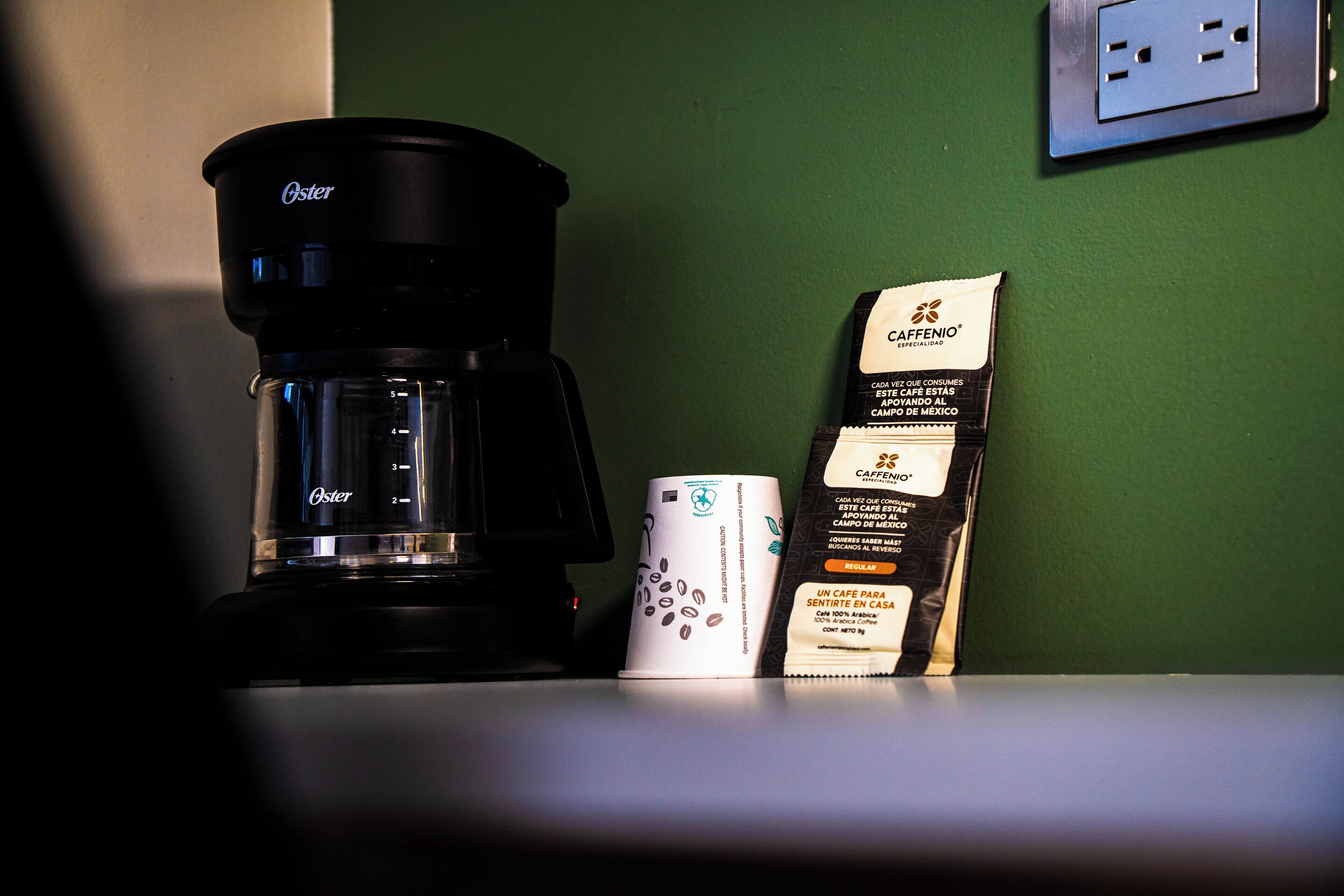 Una moka, una cialda di caffè e un sacchetto di caffè su un tavolo.